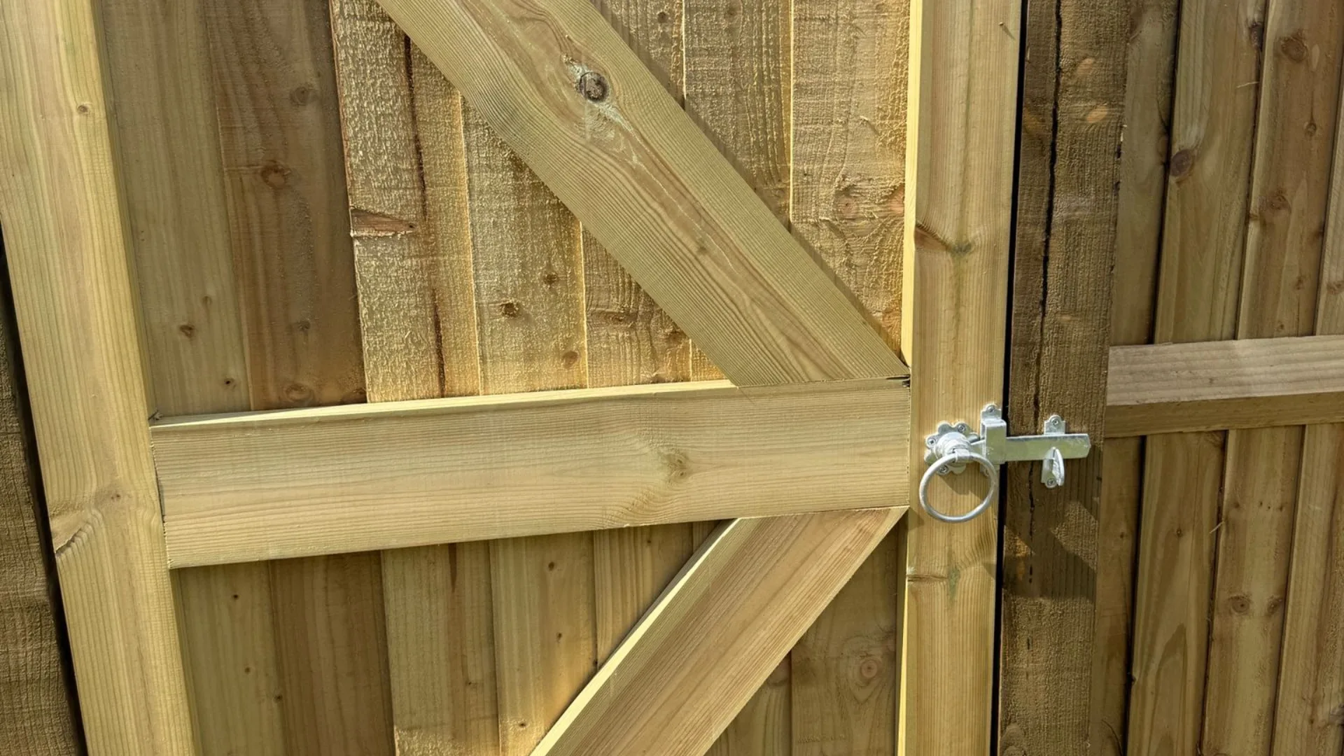 Close-up of a timber garden gate with ring latch and diagonal bracing